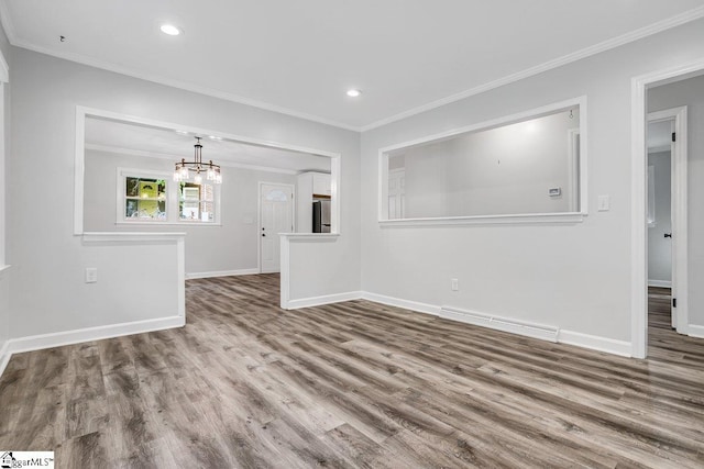 unfurnished living room featuring wood-type flooring, crown molding, and a chandelier