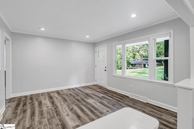 spare room featuring dark hardwood / wood-style flooring and crown molding