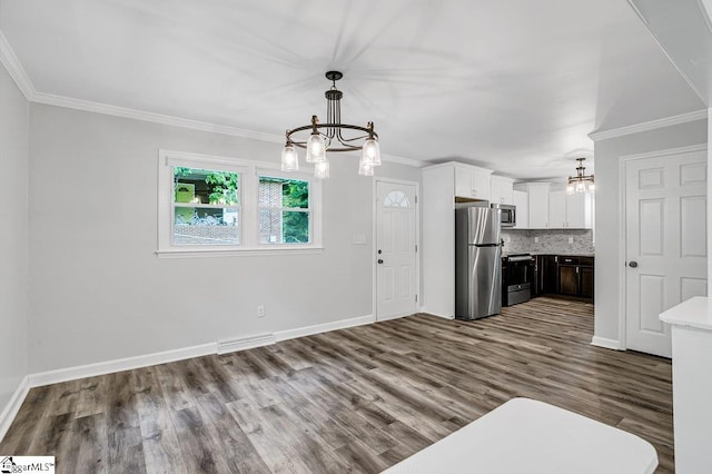 kitchen with white cabinets, stainless steel appliances, tasteful backsplash, hanging light fixtures, and a notable chandelier