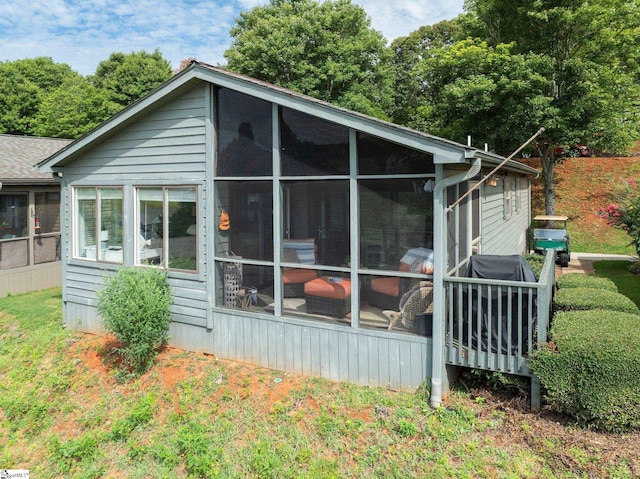 rear view of house featuring a sunroom