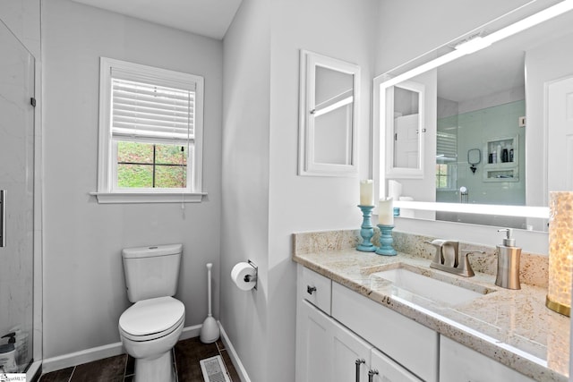 bathroom featuring toilet, vanity, tile patterned flooring, and a shower with door