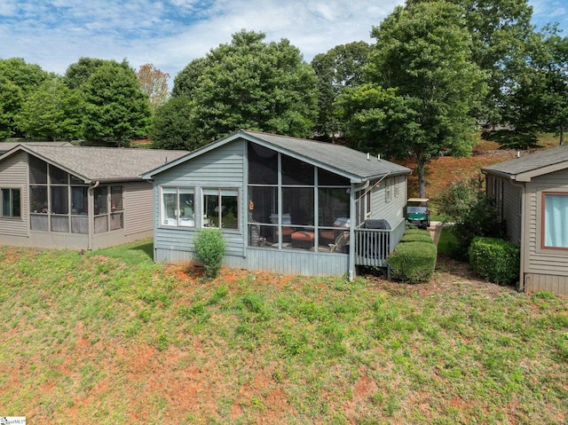 rear view of house with a sunroom and a lawn