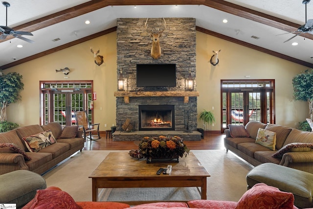 living room with french doors, plenty of natural light, a stone fireplace, and light hardwood / wood-style floors