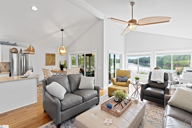 living room with ceiling fan, light hardwood / wood-style flooring, and vaulted ceiling