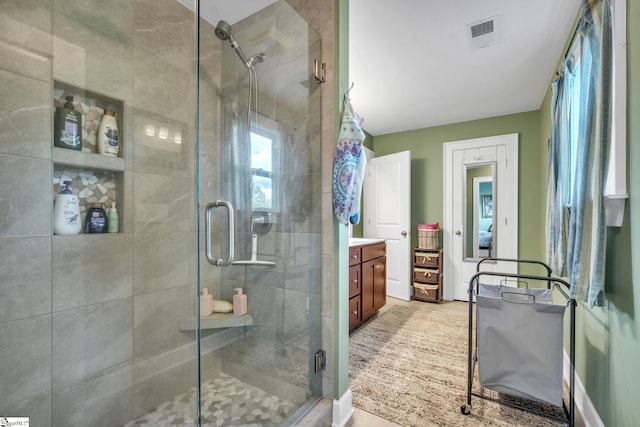 bathroom with a shower with door and vanity