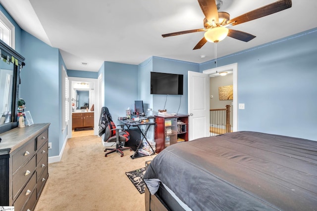 bedroom featuring ceiling fan, ensuite bath, and light carpet