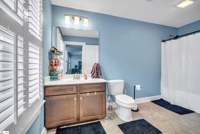 bathroom featuring tile patterned flooring, vanity, walk in shower, and toilet