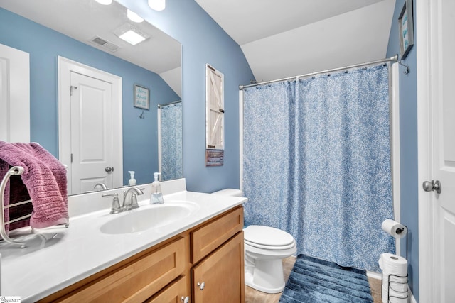 bathroom featuring vanity, vaulted ceiling, and toilet