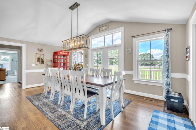 dining space featuring hardwood / wood-style flooring and lofted ceiling