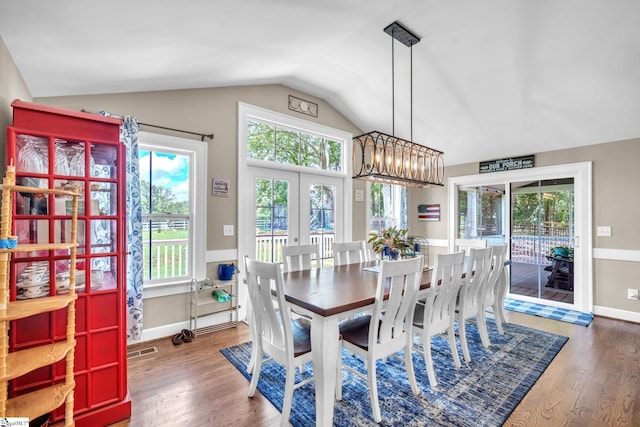 dining room featuring hardwood / wood-style floors, vaulted ceiling, and french doors