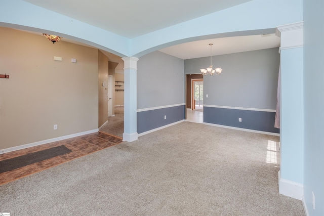 empty room featuring carpet floors, a chandelier, and ornate columns