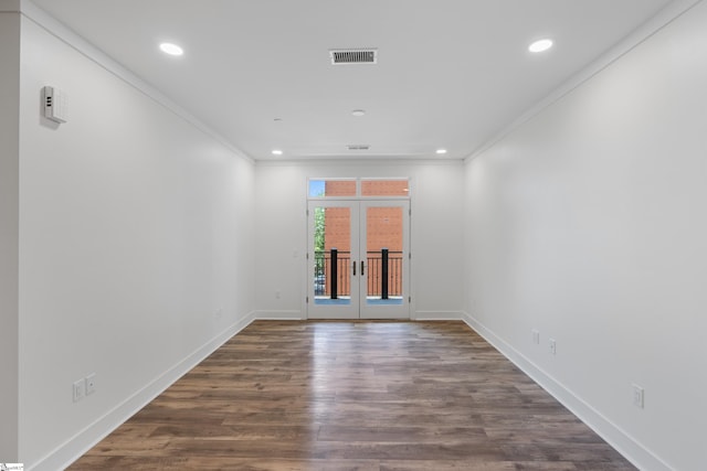 empty room with hardwood / wood-style flooring and crown molding