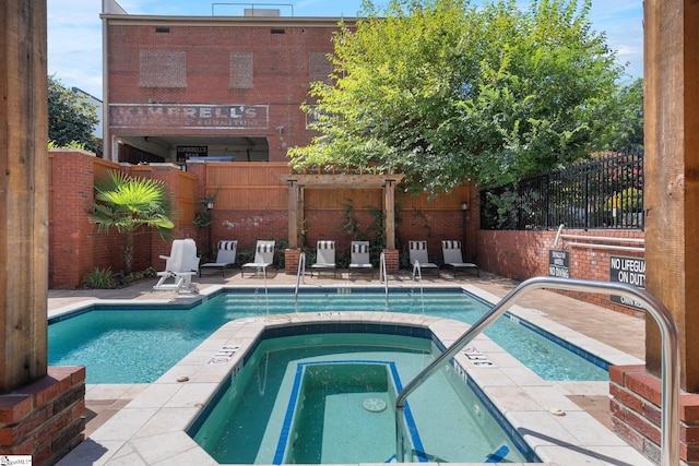 view of swimming pool with a patio and a hot tub