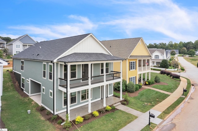 rear view of house with a balcony and a yard