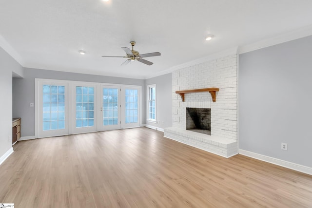 unfurnished living room with ceiling fan, a brick fireplace, light wood-type flooring, and baseboards