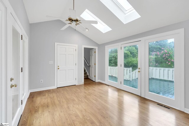 empty room with visible vents, lofted ceiling, baseboards, and light wood finished floors