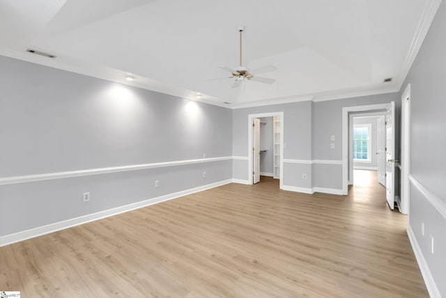 empty room featuring visible vents, a ceiling fan, crown molding, light wood finished floors, and baseboards