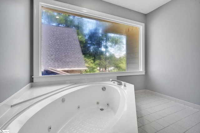 full bath with tile patterned floors, a tub with jets, and baseboards