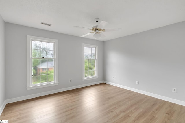 unfurnished room with plenty of natural light, visible vents, and light wood finished floors