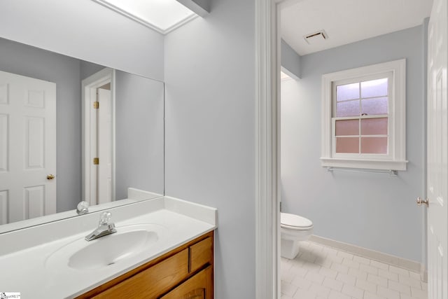 bathroom with vanity, baseboards, visible vents, tile patterned floors, and toilet