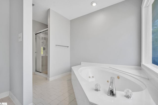 bathroom featuring tile patterned floors, a wealth of natural light, a stall shower, and a whirlpool tub