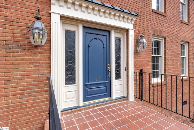 view of exterior entry featuring brick siding