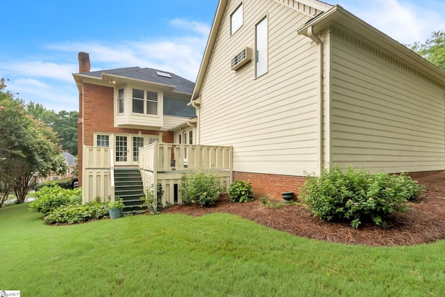 rear view of house with a wall mounted AC, a yard, a chimney, stairs, and a deck