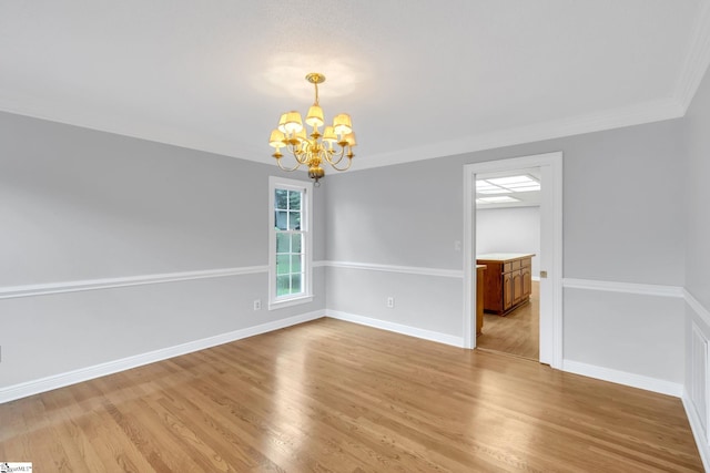 empty room with baseboards, a notable chandelier, crown molding, and light wood finished floors