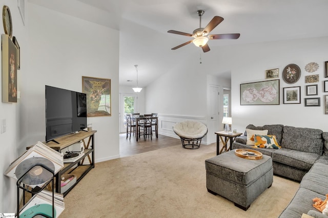 living room featuring high vaulted ceiling, ceiling fan, and light colored carpet