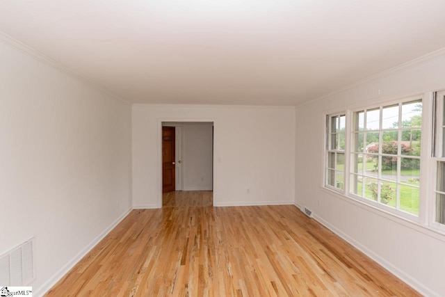 empty room featuring crown molding and light hardwood / wood-style floors