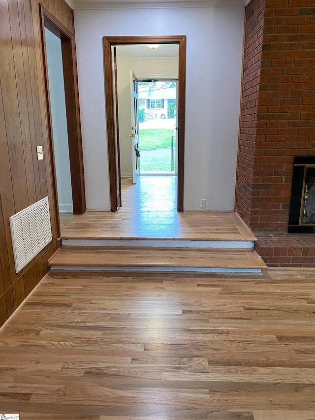 corridor featuring wooden walls and light hardwood / wood-style floors