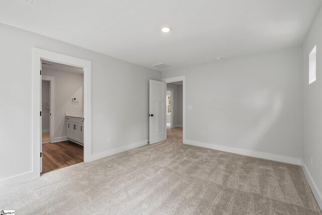 unfurnished bedroom featuring carpet floors and ensuite bath