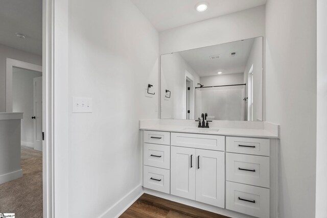 bathroom with vanity, hardwood / wood-style flooring, and walk in shower