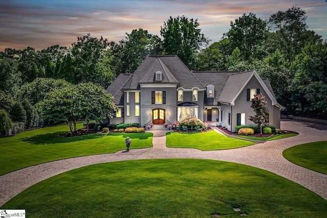 french country home featuring a lawn