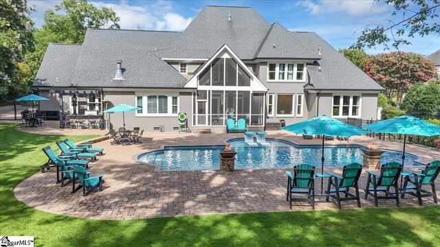 rear view of house with a patio area and a sunroom