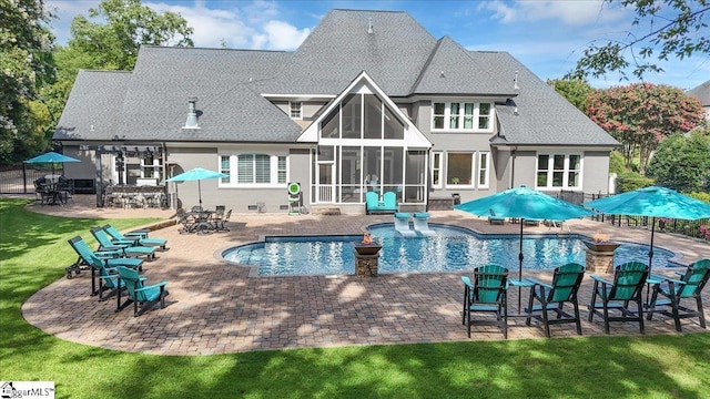 rear view of house with a patio, a sunroom, and a yard