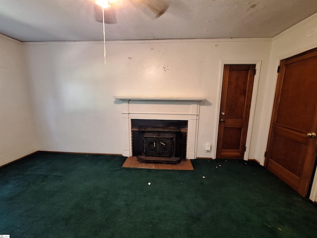 unfurnished living room featuring a wood stove, carpet flooring, and ceiling fan