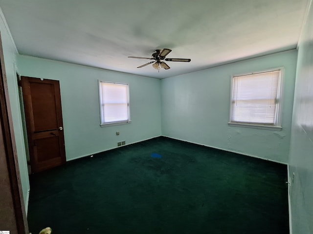 carpeted spare room featuring ceiling fan