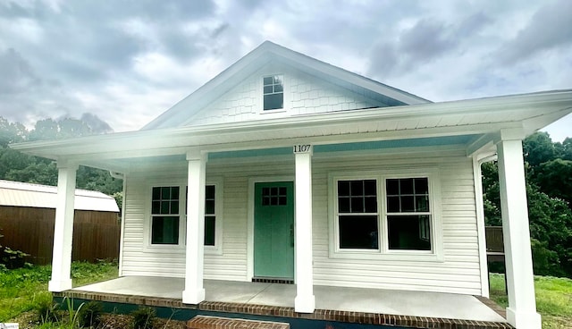 rear view of house featuring covered porch