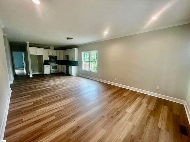 unfurnished living room with light hardwood / wood-style flooring and ornamental molding