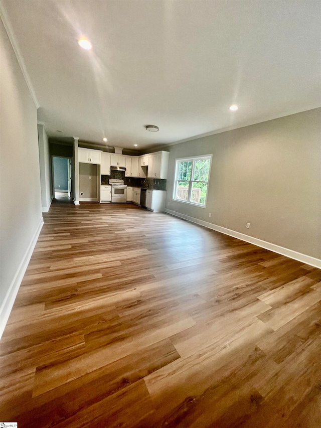 unfurnished living room featuring light hardwood / wood-style floors and ornamental molding