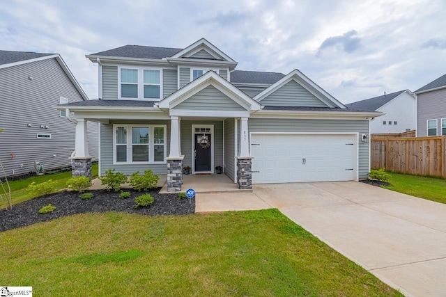 craftsman inspired home with a garage, a front lawn, and covered porch