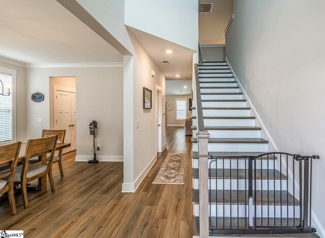 dining area featuring ornamental molding, dark hardwood / wood-style flooring, and a healthy amount of sunlight