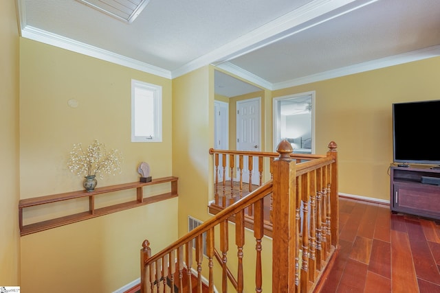 corridor featuring ornamental molding, dark wood-style flooring, an upstairs landing, and baseboards