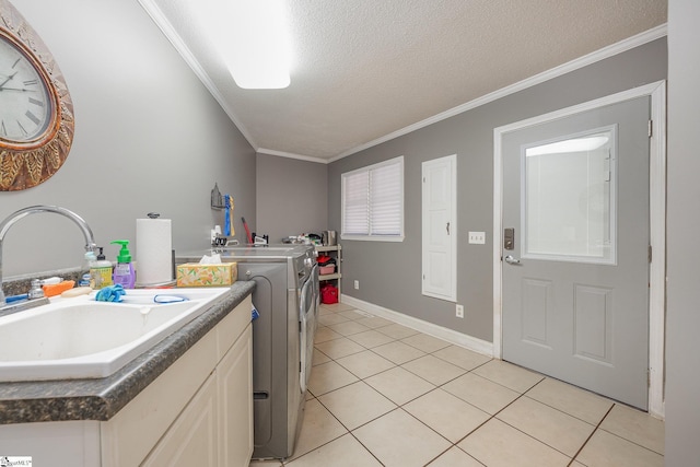 clothes washing area with washer and dryer, laundry area, light tile patterned flooring, and a sink