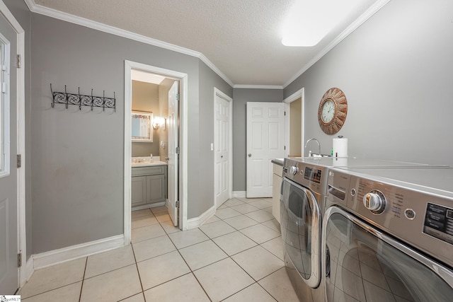 laundry area with crown molding, light tile patterned floors, washing machine and dryer, a textured ceiling, and laundry area