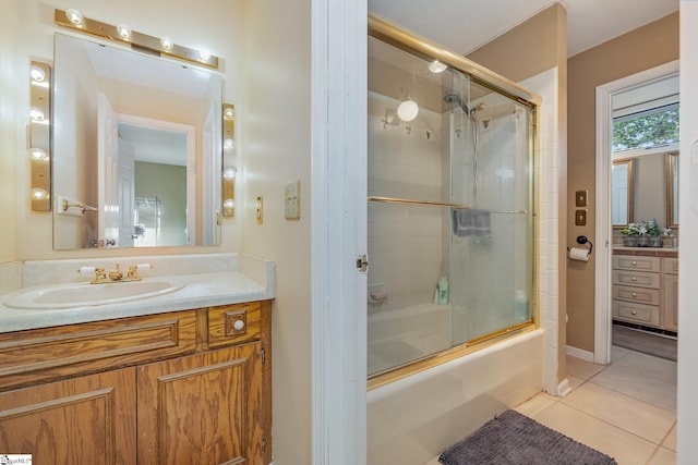 bathroom featuring tile patterned flooring, combined bath / shower with glass door, and vanity