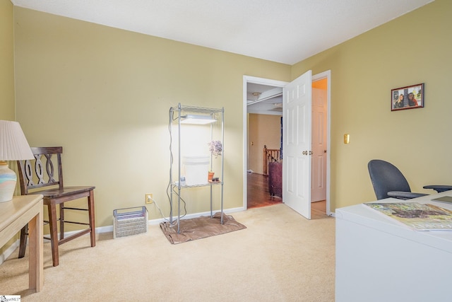 office space with washer / dryer, light colored carpet, and baseboards