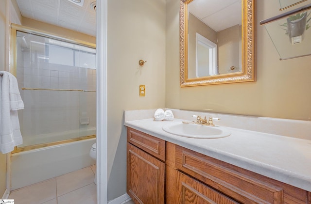 full bathroom featuring toilet, shower / bath combination with glass door, vanity, and tile patterned floors