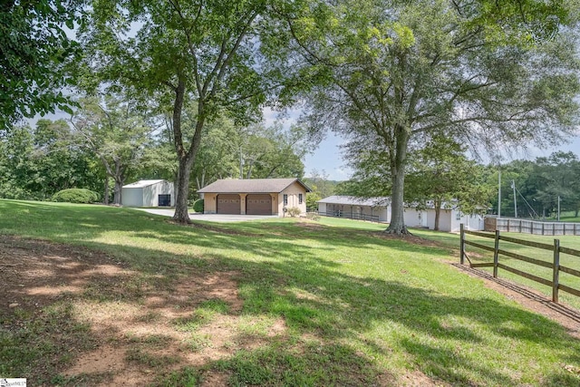 view of yard with an outbuilding, fence, and a garage